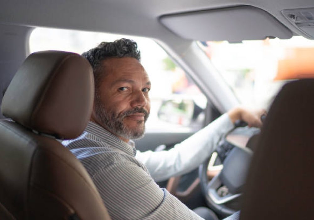 Portrait of businessman looking at camera inside the car